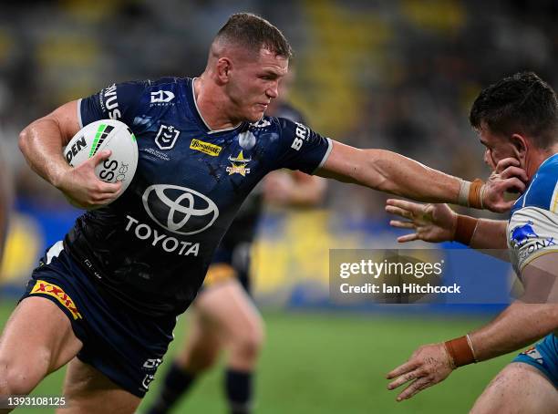 Tom Gilbert of the Cowboys fends off Beau Fermor of the Titans during the round seven NRL match between the North Queensland Cowboys and the Gold...