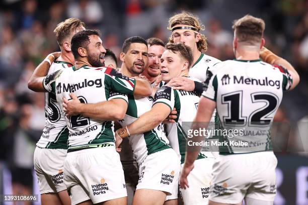 Cody Walker of the Rabbitohs celebrates with his team mates after scoring a try during the round seven NRL match between the Wests Tigers and the...