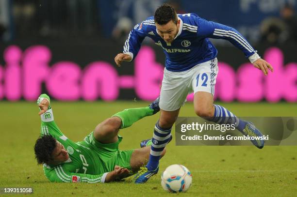 Christian Traesch of Wolfsburg and Marco Hoeger of Schalke battle for the ball during the Bundesliga match between FC Schalke 04 and VfL Wolfsburg at...