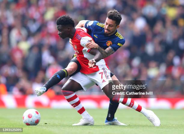 Bukayo Saka of Arsenal battles for possession with Alex Telles of Manchester United during the Premier League match between Arsenal and Manchester...