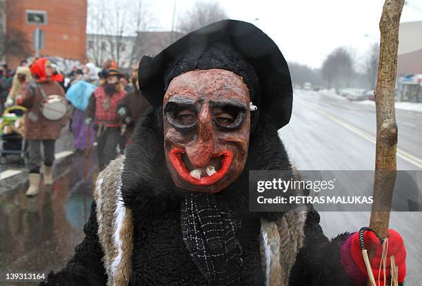 Revellers wearing masks and dressed up as Gypsies, devils, witches, horses, goats and others parade in the streets of the old town of Klaipeda on...