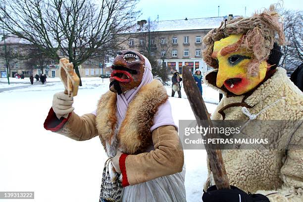 Revellers wearing masks and dressed up as Gypsies, devils, witches, horses, goats and others parade in the streets of the old town of Klaipeda on...