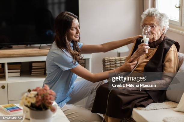 krankenschwester häusliche gesundheitspflege inhalationsbehandlung für asthmatische senioren - atmungsorgan stock-fotos und bilder