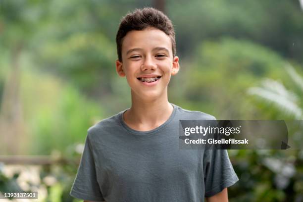 teen boy with braces smiling outside in summer - tienerjongens stockfoto's en -beelden