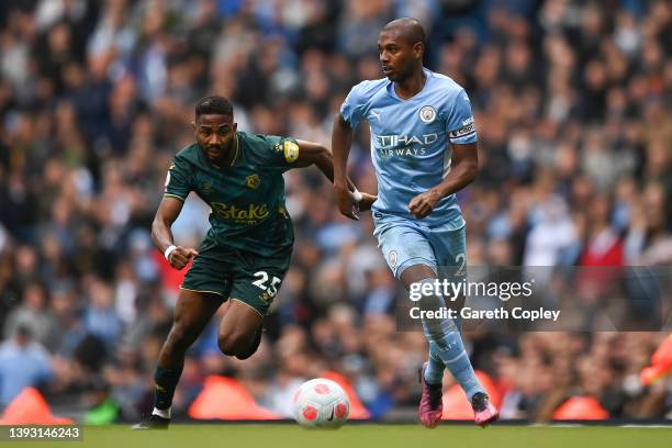 Fernandinho of Manchester City is challenged by Emmanuel Dennis of Watford FC during the Premier League match between Manchester City and Watford at...