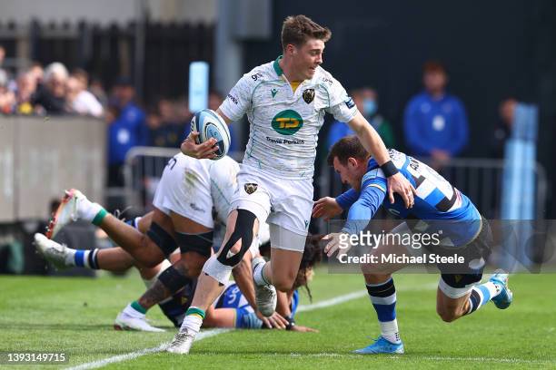 Tommy Freeman of Northampton looks for support as Bath's Ben Spencer makes a tackle during the Gallagher Premiership Rugby match between Bath Rugby...