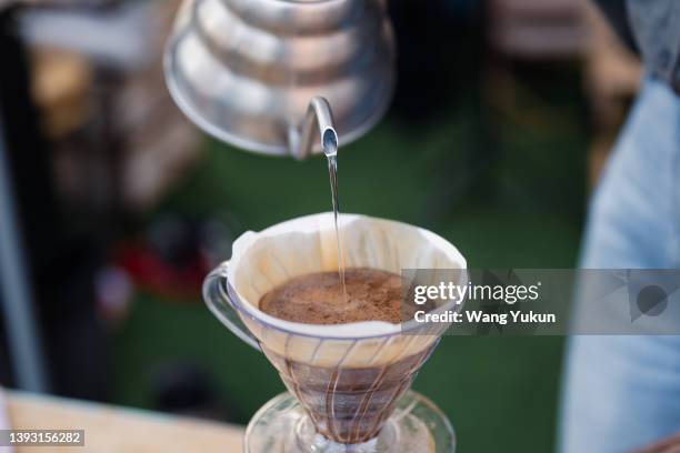 close-up of young female barista making coffee - coffee drip ストックフォトと画像