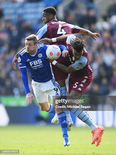 Jamie Vardy of Leicester City is challenged by Tyrone Mings and Ezri Konsa of Aston Villa during the Premier League match between Leicester City and...