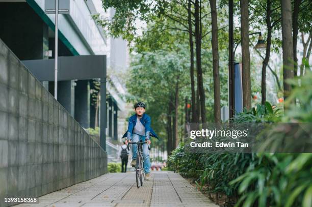 asiático chinês homem ciclismo na cidade em ciclovia - single lane road - fotografias e filmes do acervo