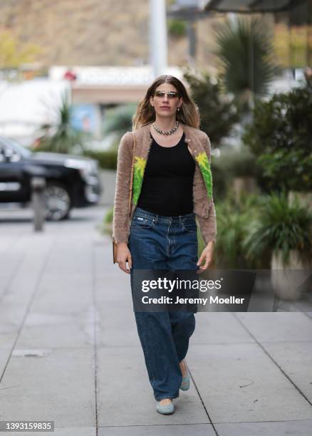 Veronika Heilbrunner seen wearing a brown Miu Miu sunglasses, a silver pearl necklace, a black top from Zara, a fluffy beige cardigan with...