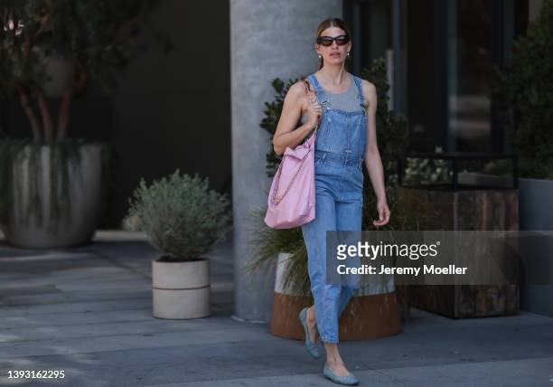Veronika Heilbrunner seen wearing a black sunglasses, pearl earrings, a grey top from Zara, a blue denim overall from Calvin Klein, a light pink...