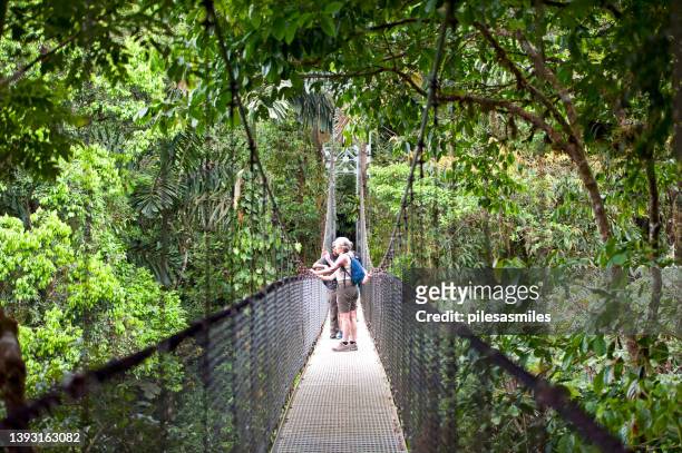 tourists on hanging bridge, arenal, costa rica - arenal volcano national park stock pictures, royalty-free photos & images