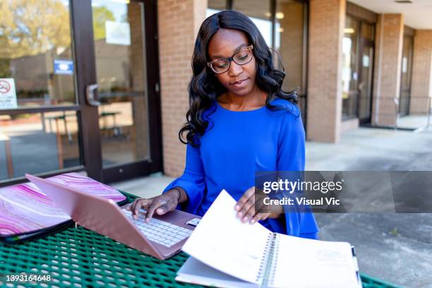 teacher using device outside - administrative professionals day stockfoto's en -beelden