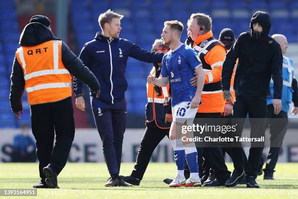Davis Keillor-Dunn of Oldham Athletic is escorted off the pitch by stewards as Oldham Athletic fans protest on the pitch leading to the match to be...