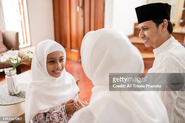 asian family, celebrating eid-ul-fitr at home, asking forgiveness - eid al fitr celebration to mark the end of ramadan stockfoto's en -beelden