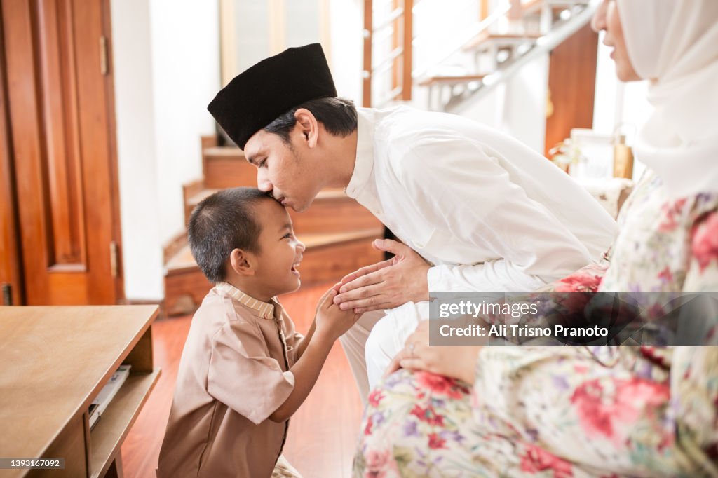 Asian family, celebrating Eid-Ul-Fitr at home, asking forgiveness