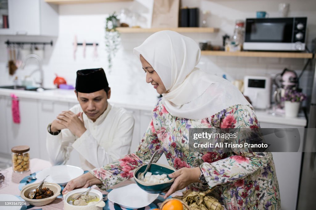 Asian family, celebrating Eid-Ul-Fitr at home, preparing food