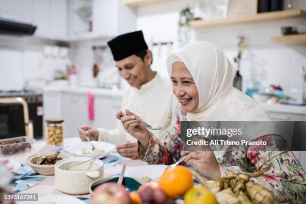 asian family, celebrating eid-ul-fitr, having meal together - familie zuhause essen stock-fotos und bilder