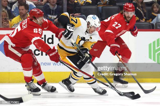 Sidney Crosby of the Pittsburgh Penguins battles for the puck between Danny DeKeyser and Michael Rasmussen of the Detroit Red Wings during the first...