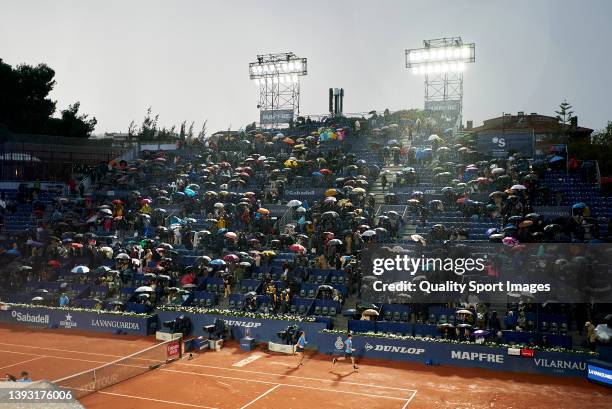 Umbrellas are raised as play is suspended during day six of the Barcelona Open Banc Sabadell at Real Club De Tenis Barcelona on April 23, 2022 in...