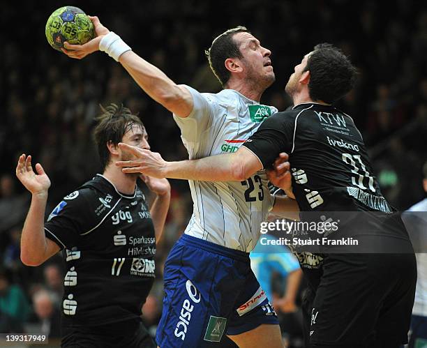 Pascal Hens of Hamburg is challenged by Nicolas Ivakno and Norman Floedl of Hildesheim during the Toyota Bundesliga match between Eintracht...