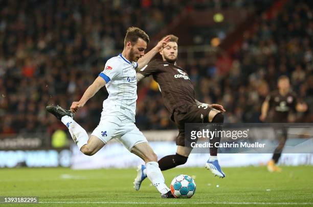 Matthias Bader of SV Darmstadt 98 is challenged by Marcel Hartel of FC St. Pauli during the Second Bundesliga match between FC St. Pauli and SV...