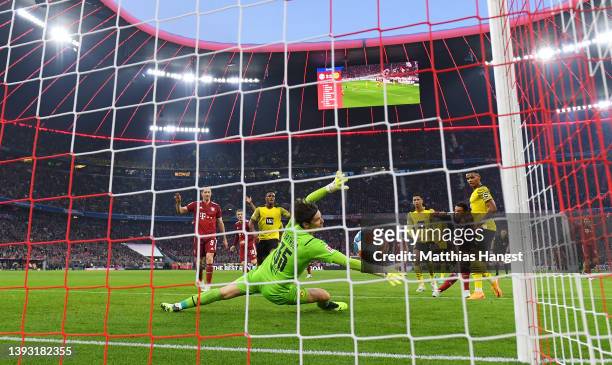 Jamal Musiala of FC Bayern Muenchen scores their team's third goal past Marwin Hitz of Borussia Dortmund during the Bundesliga match between FC...