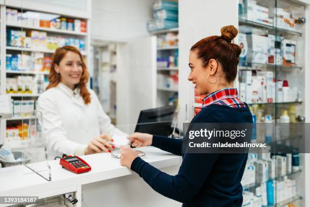 pharmacies and chemists - paying doctor stock pictures, royalty-free photos & images