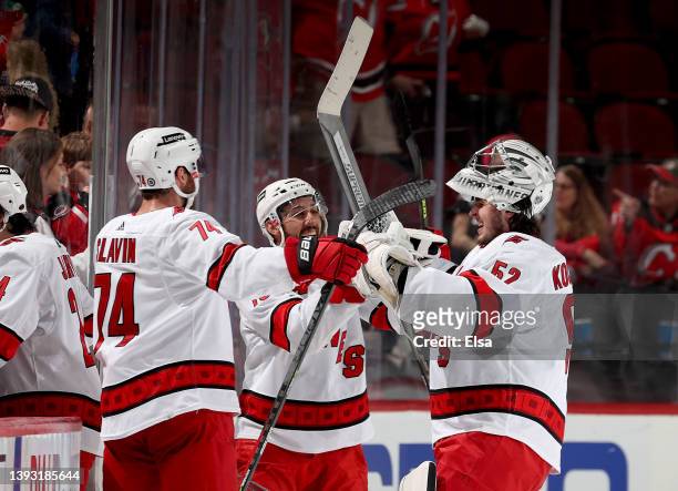 Jaccob Slavin and Vincent Trocheck of the Carolina Hurricanes celebrate the win with Pyotr Kochetkov after the game against the New Jersey Devils at...