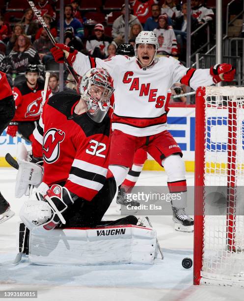 Jon Gillies of the New Jersey Devils is unable to stop a shot as Jesper Fast of the Carolina Hurricanes celebrates during the third period at...