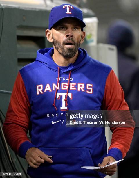 Manager Chris Woodward of the Texas Rangers looks on from the dugout against the Oakland Athletics in the bottom of the eighth inning at RingCentral...