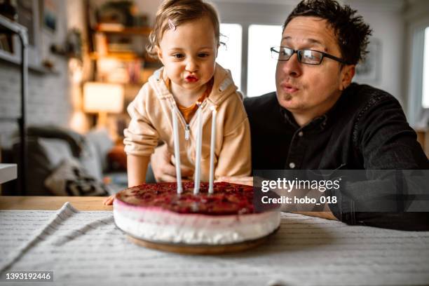 girl celebrating birthday with father at home - sharing cake stock pictures, royalty-free photos & images