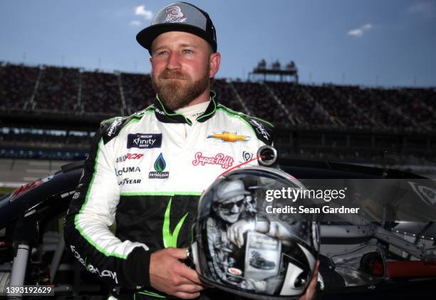Jeffrey Earnhardt, driver of the ForeverLawn Chevrolet, poses, displaying his helmet with an artist rendering of his grandfather Dale Earnhardt Sr....