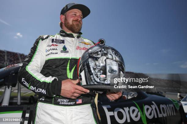Jeffrey Earnhardt, driver of the ForeverLawn Chevrolet, poses, displaying his helmet with an artist rendering of his grandfather Dale Earnhardt Sr....