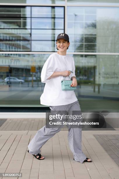 Influencer Maria Barteczko wearing a white oversized shirt by Vival Studio, white and blue striped denim jeans pants by Lioness, black oran sandals...