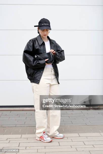 Influencer Maria Barteczko wearing a black leather bomber jacket by Pixie Market, a white rib tank top by Arket, beige wide leg denim jeans by Zara,...