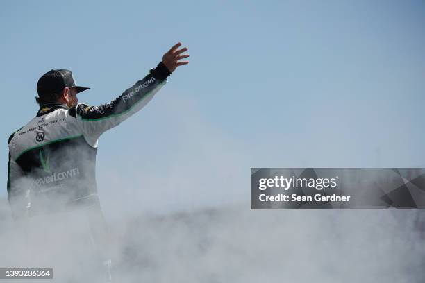 Jeffrey Earnhardt, driver of the ForeverLawn Chevrolet, waves to fans during driver intros prior to the NASCAR Xfinity Series Ag-Pro 300 at Talladega...