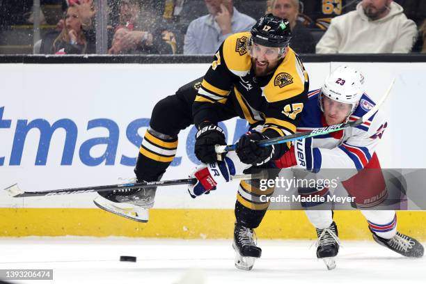 Adam Fox of the New York Rangers and Nick Foligno of the Boston Bruins battle for control of the puck during the third period at TD Garden on April...