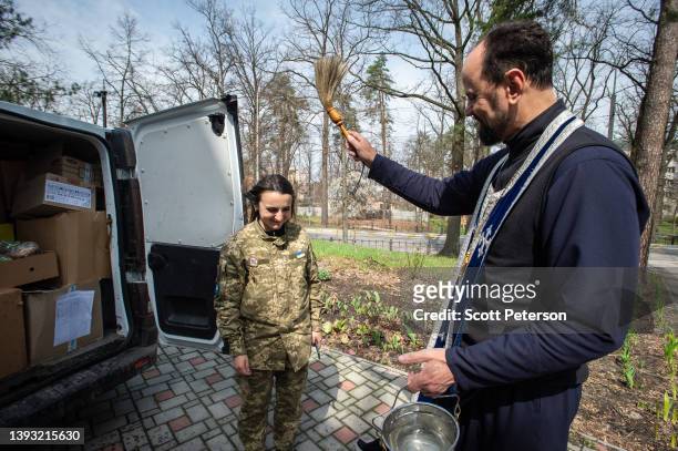 Orthodox Father Andriy Kliushev blesses Easter cakes with holy water for a Ukrainian Army battalion, as Ukrainian Orthodox priests prepare to...