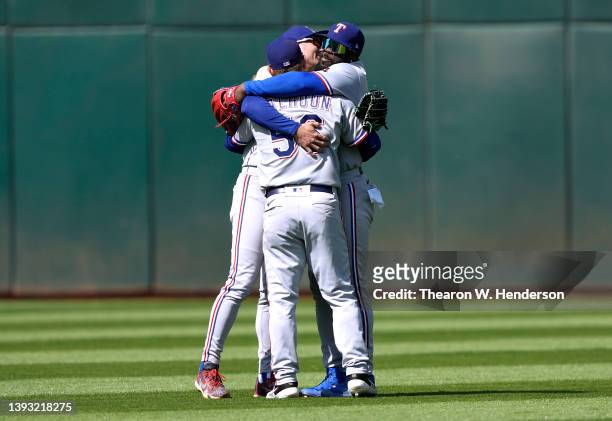 Brad Miller, Kole Calhoun and Adolis Garcia of the Texas Rangers celebrate defeating the Oakland Athletics 2-0 at RingCentral Coliseum on April 23,...