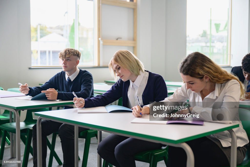 Students taking educational exam in secondary classroom