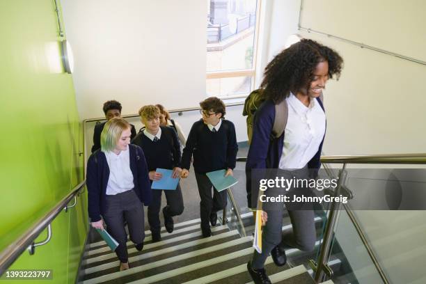 secondary students walking up staircase in school building - british culture walking stock pictures, royalty-free photos & images