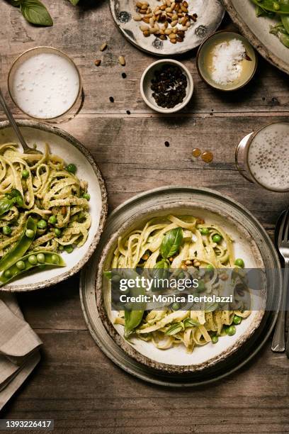pesto and fresh pea linguine pasta on rustic wooden table - pesto imagens e fotografias de stock