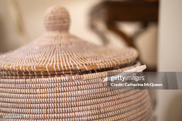 handwoven rattan seagrass lidded basket being used as clothes hamper - laundry basket imagens e fotografias de stock