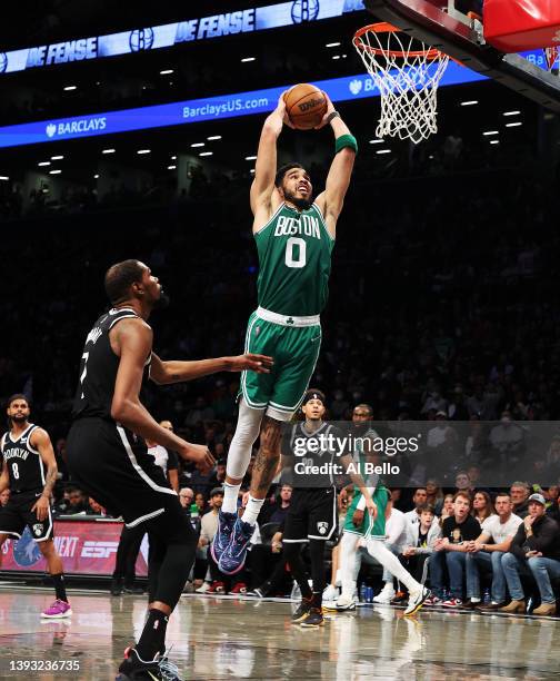 Jayson Tatum of the Boston Celtics dunks against Kevin Durant of the Brooklyn Nets during Game Three of the Eastern Conference First Round NBA...