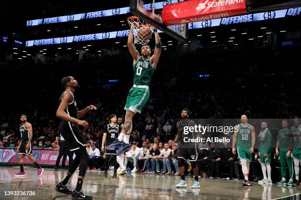 Jayson Tatum of the Boston Celtics dunks against Kevin Durant of the Brooklyn Nets during Game Three of the Eastern Conference First Round NBA...