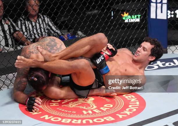 Claudio Puelles of Peru works for a submission against Clay Guida in a lightweight fight during the UFC Fight Night event at UFC APEX on April 23,...