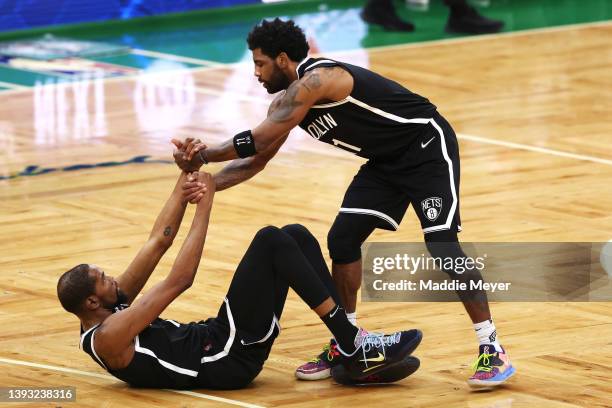 Kyrie Irving of the Brooklyn Nets helps up Kevin Durant during the fourth quarter of Game Two of the Eastern Conference First Round NBA Playoffs at...