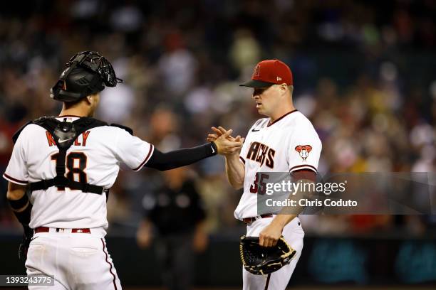 Carson Kelly shakes hands with Joe Mantiply of the Arizona Diamondbacks after the final out of the game against the New York Mets at Chase Field on...