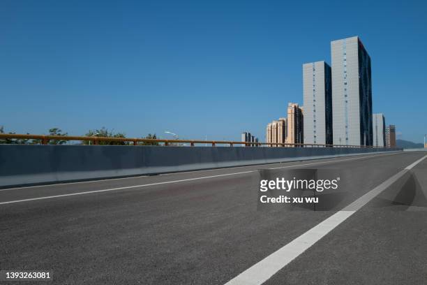 empty asphalt road beside the city - street clear sky stock pictures, royalty-free photos & images
